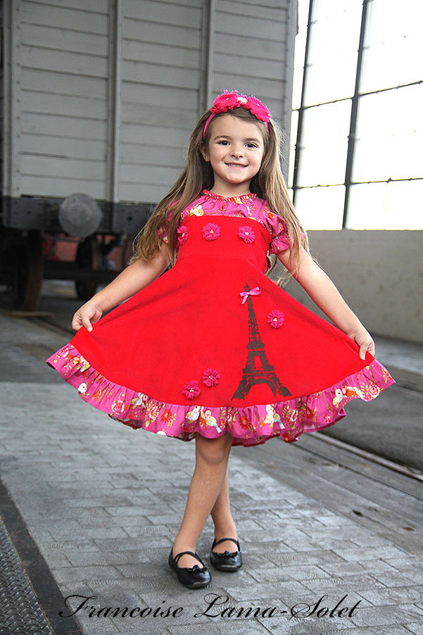 Girl's red corduroy ruffled twirl dress with shoulder straps hand printed with the Eiffel Tower Voyage Reagan